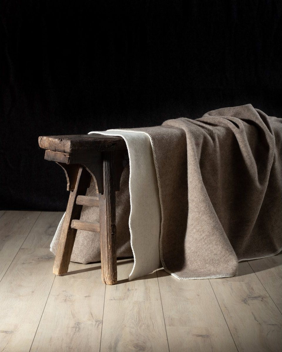 Wollen deken van MoST over een houten krukje