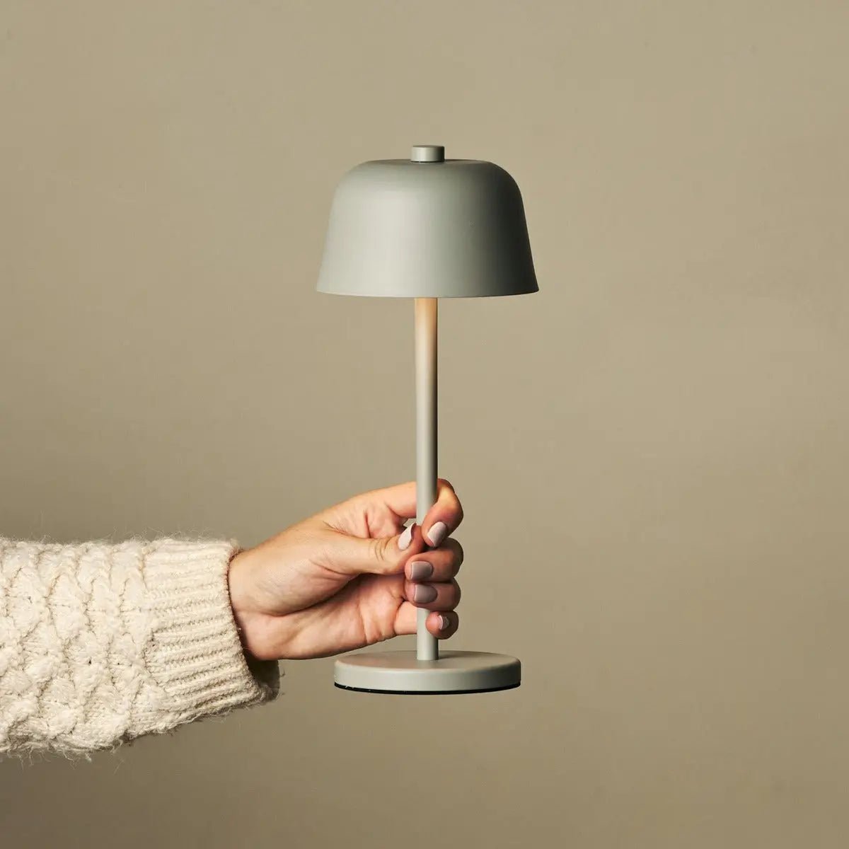 RedUse - hand met saliegroene oplaadbare tafellamp